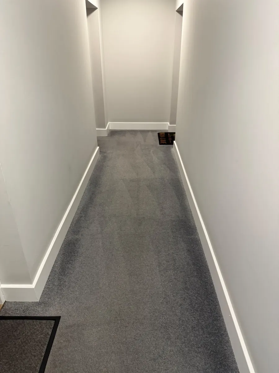 Carpeted corridor with a doormat in the foreground